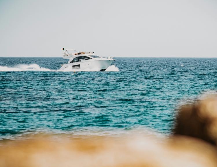 un bateau sur la mer avec un rocher au premier plan