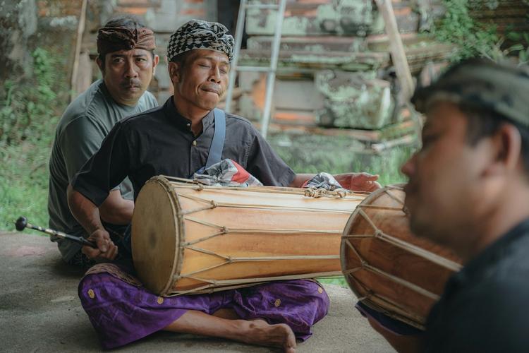 un groupe d'hommes assis qui jouent des instruments de musique