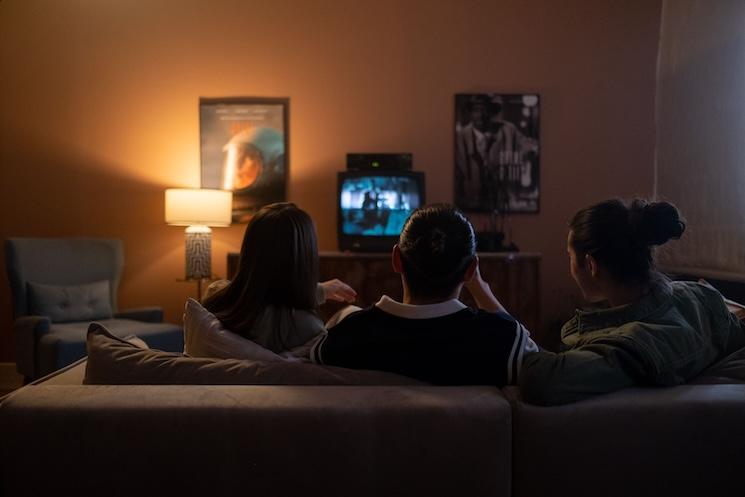 Des gens regardent la tv ensemble sur un canapé