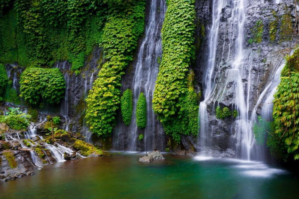 une cascade qui s'écoule d'une falaise avec de la végétation autour