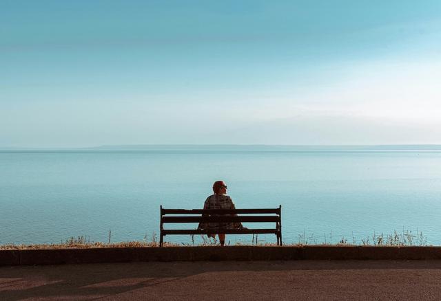 être seul sur un banc face à la mer en expatriation