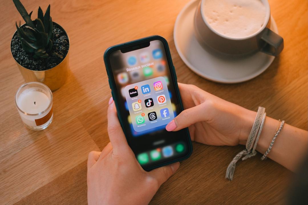 photo d'un téléphone et d'une personne utilisant les réseaux sociaux