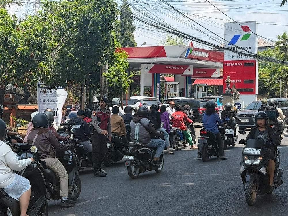 des scooter et voitures devant une station essence à bali