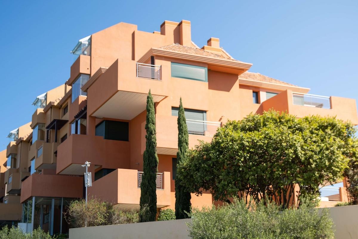 Immeuble résidentiel moderne aux façades ocre et aux balcons en Espagne, illustrant le marché immobilier et le choix entre acheter ou louer en 2026.