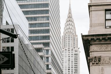 Vue détaillée de la flèche emblématique et de la façade en acier inoxydable du Chrysler Building à New York, un exemple magistral de l'architecture Art déco.