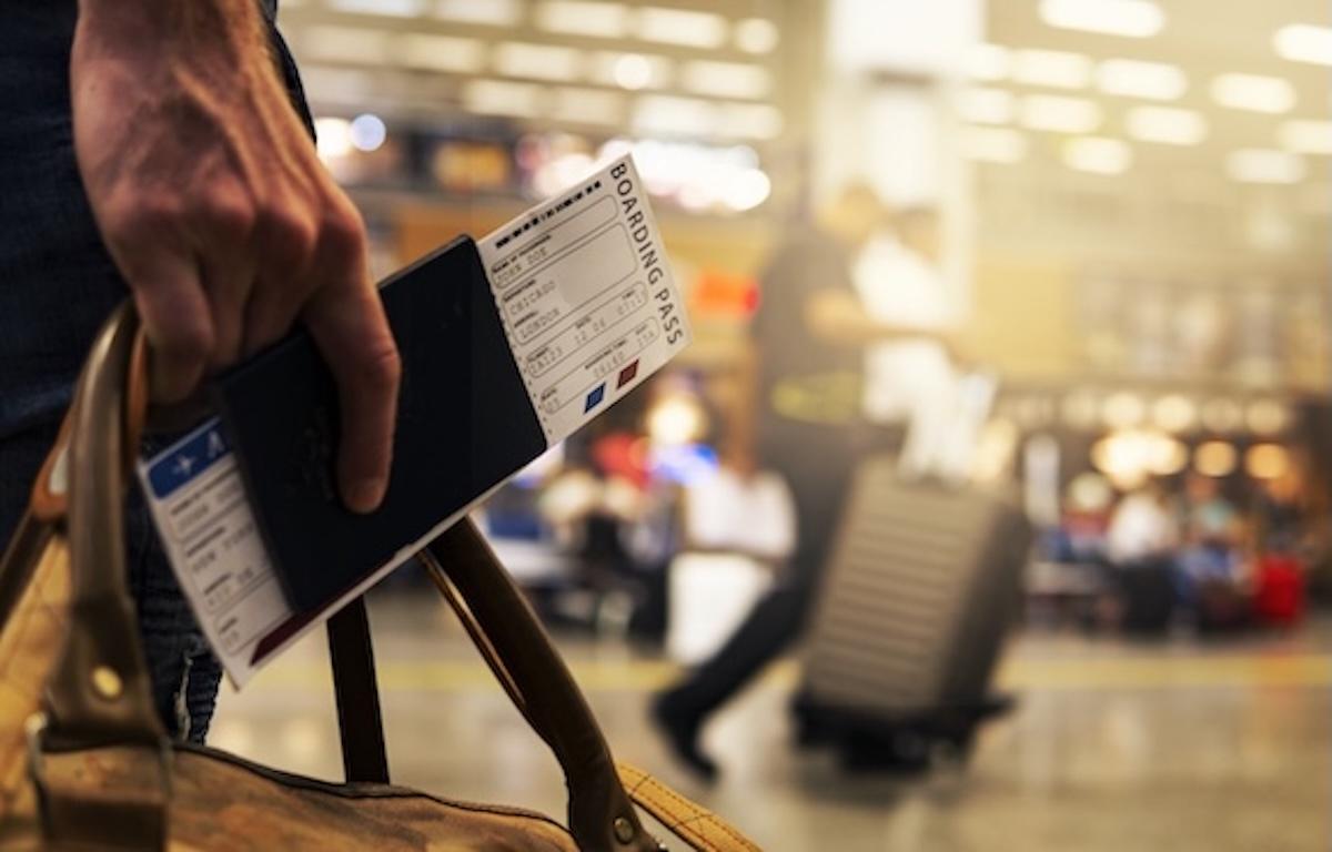 Voyageur tenant un passeport et une carte d’embarquement dans un aéroport