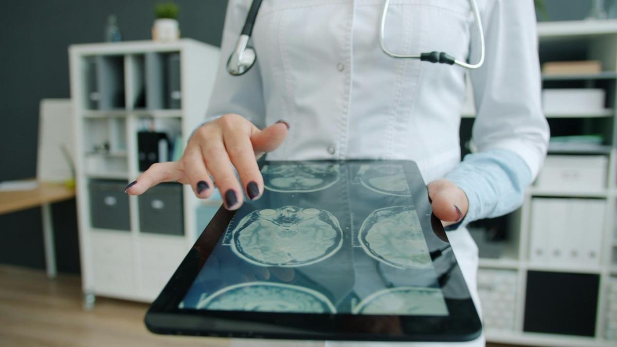 Médecin consultant des images cérébrales sur une tablette numérique