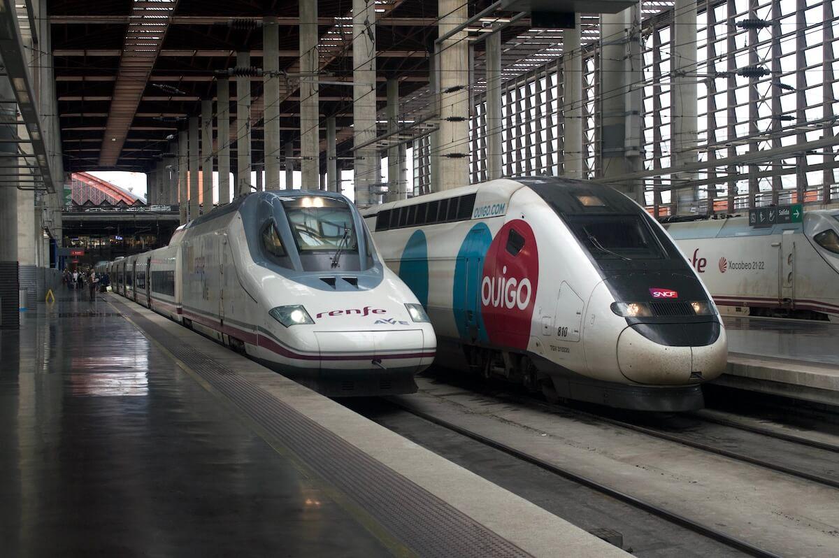 Deux trains à grande vitesse Renfe AVE et Ouigo côte à côte à la gare de Madrid-Atocha, en Espagne.