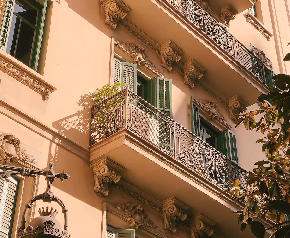 Façade colorée d'un immeuble résidentiel avec balcons et volets dans le quartier gothique de Barcelone, en Espagne.
