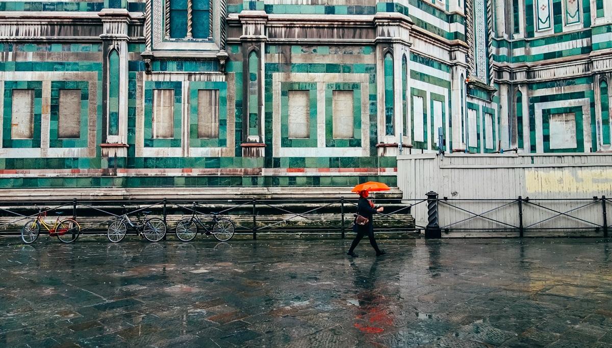 personne tenant un parapluie sous la pluie en italie