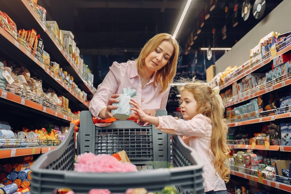 Une mère et sa fille font leurs courses dans un supermarché, illustration des conditions de vie des familles en Espagne.