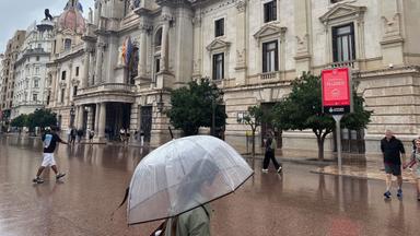 personnes marchant sous la pluie avec un parapluie place de la mairie à valence