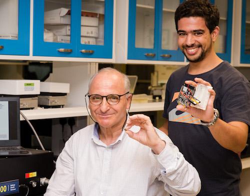 NTU Prof Rachid Yazami left holding his smart battery chip with research fellow Sohaib El Outmani holding a prototype testing device