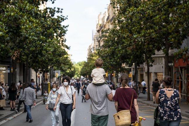 des gens se promènent dans une rue de Barcelone