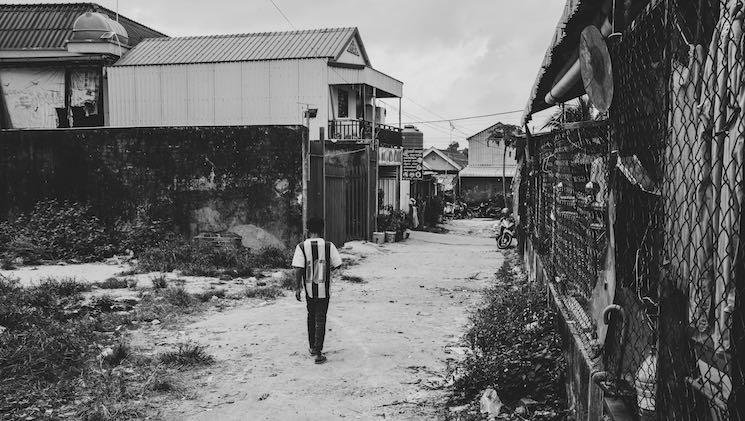 Klang Leu, un enfant traverse seul une ruelle du quartier.