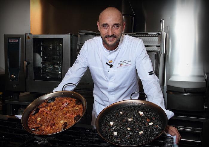 un cuisinier avec 2 paellas