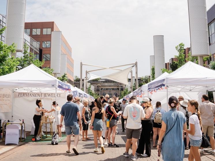Entre les tentes blanches du marché, visiteurs, expatriés et curieux déambulent dans Fillmore Plaza lors de Bastille Day 2025, devenu aujourd'hui le Denver French Fest. Crédit photo : Mio de Photomaki (@Photomaki)