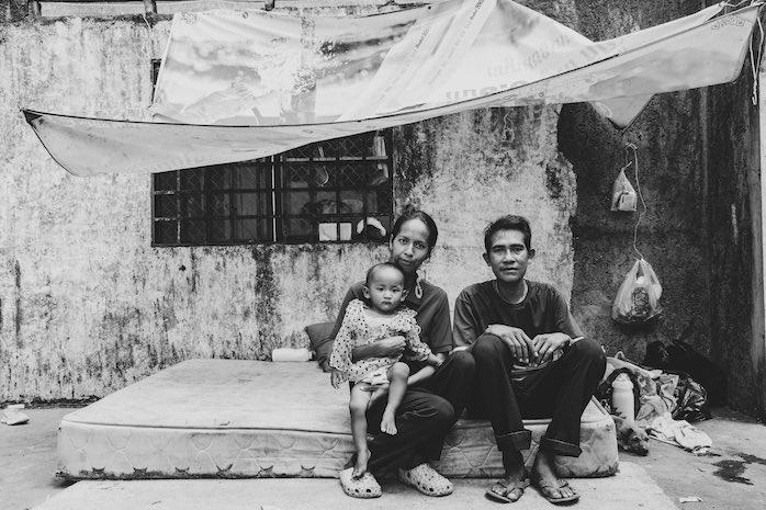 une famille abrite sa vie sous une bâche, entre les murs d'une maison en ruine