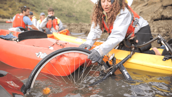 une personne sort un velo de la rivière