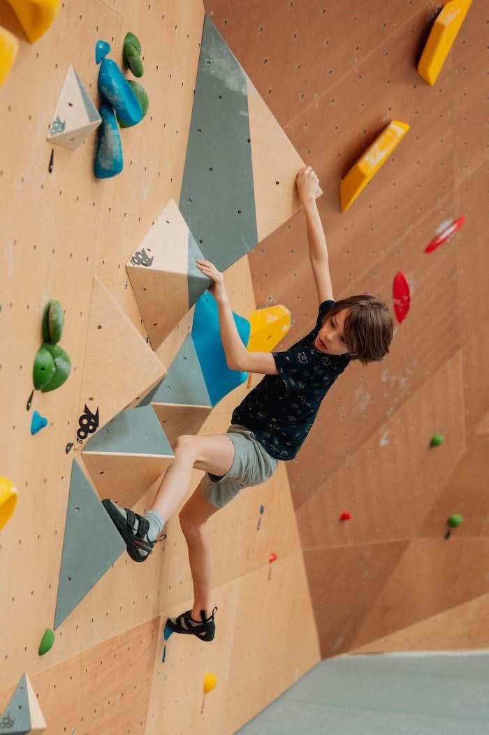 un enfant escalade un mur