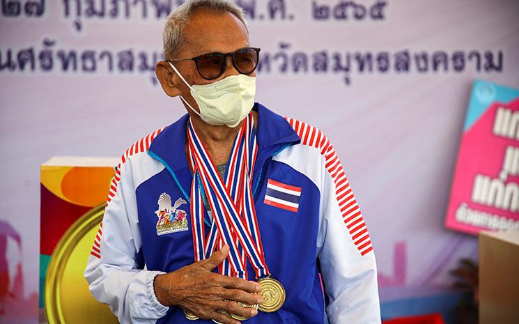 Le centenaire Sawang Janpram montres ses medailles d'athletisme remportees lors d'un championnat senior en Thailande