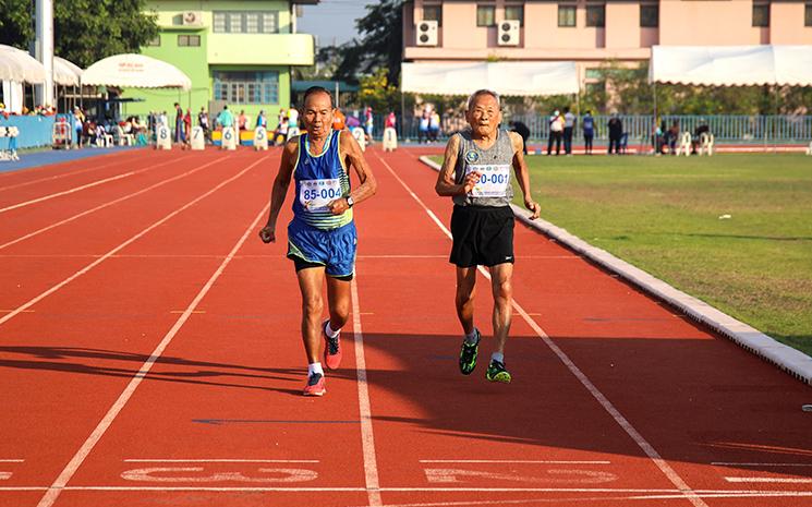 Un centenaire thailandais court un 100 mètres lors d'un championnat d'athletisme
