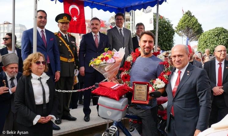 Edremit, je suis reçu dans le cortège de célébration du centenaire de la république Turque avec le préfet qui me remet le drapeau de la Turquie pour saluer mon aventure.