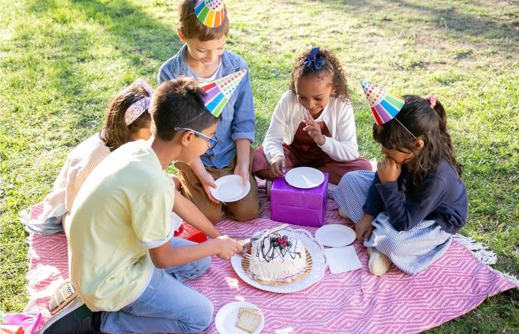 Des enfants dans un parc célébrant un anniversaire