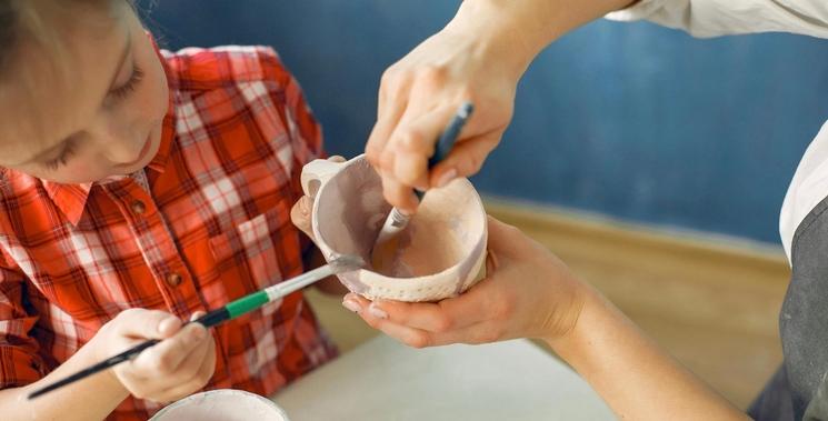 Un enfant peignant de la poterie