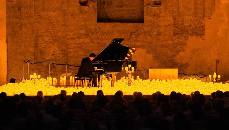 Un pianiste entouré de bougies allumées