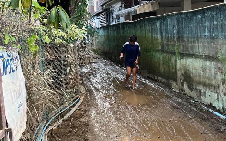 Une jeune thailandaise marche dans une rue boueuse de Chiang Mai apres de fortes inondations