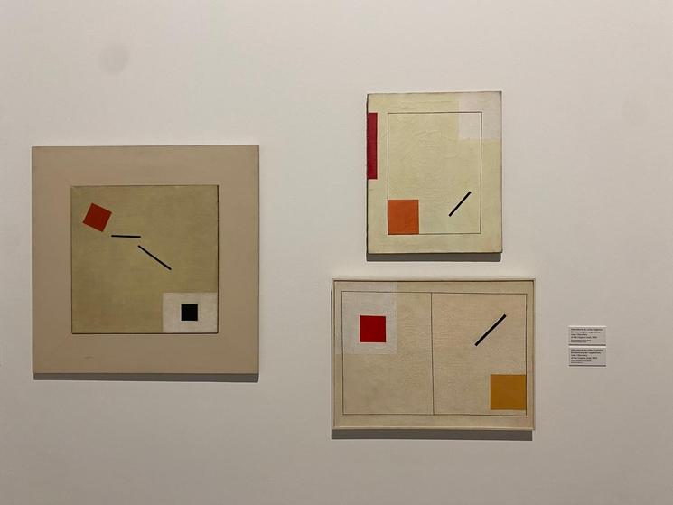 Trois tableaux au fond blanc avec motifs géométriques noirs et rouges