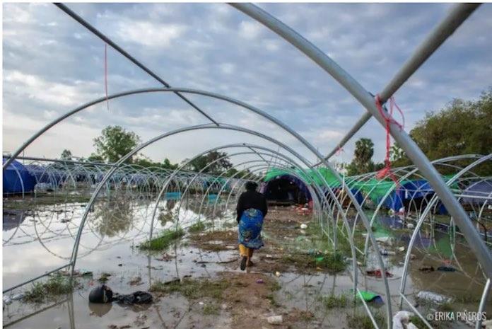 Yorn Ya passe devant des tentes vides dans son camp de déplacés inondé. 6 mars 2026 (Photo gracieusement fournie par Erika Pineros/erikapineros.com)