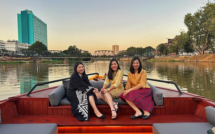 Trois dames thailandaises sur la proue du bateau de croisiere fluviale de l'hotel Anantara Chiang Mai