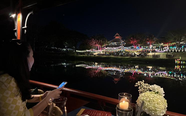 Vue des berges la nuit depuis le bateau croisiere de l'hotel Anantara Chiang Mai
