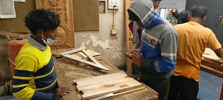 Des apprentis en train de fabriquer une pièce en bois