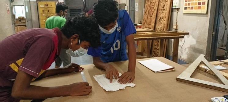 Report d’un schéma sur une pièce de bois par les apprentis