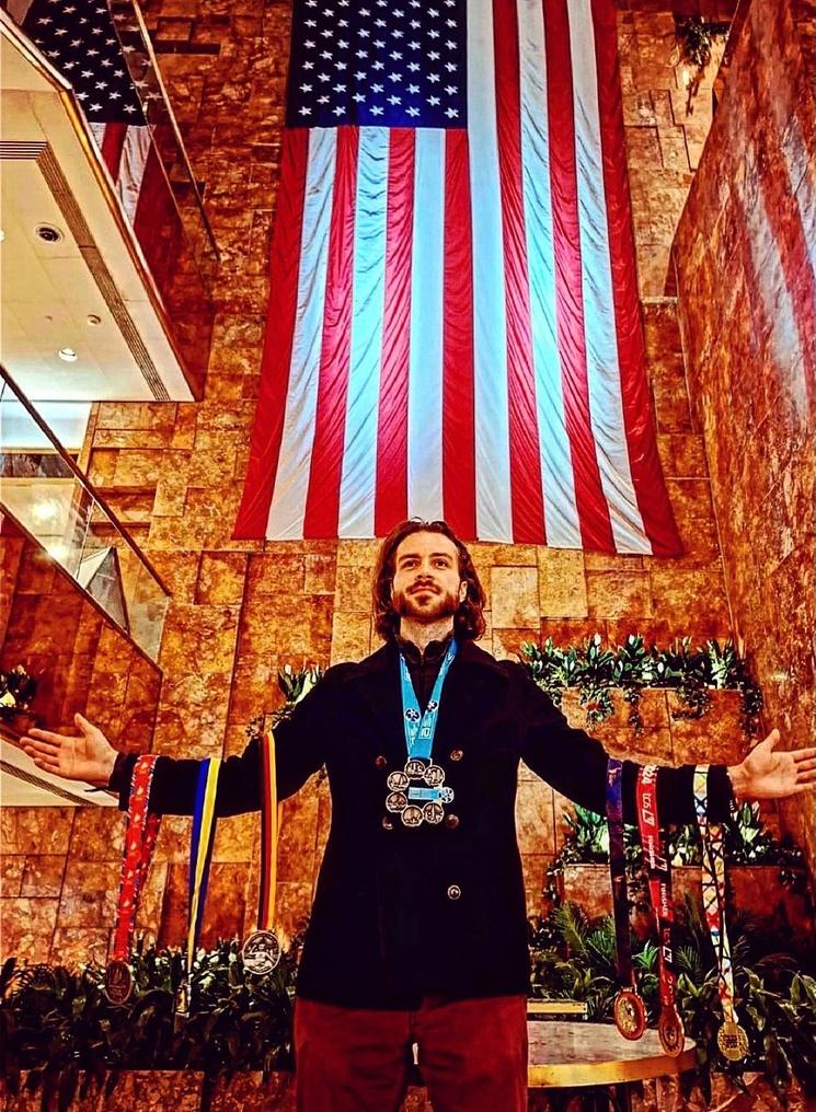 Elvin Leroux avec ses médailles devant un drapeau américain