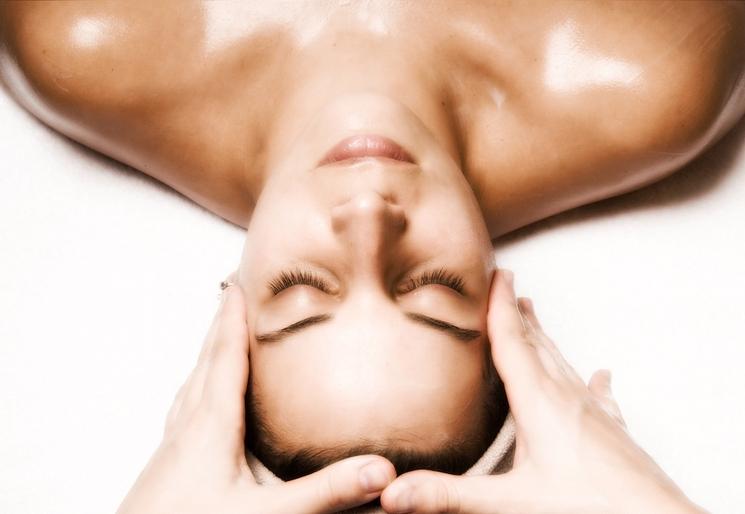 femme en train de se faire masser le visage à l'envers par des mains d'une esthéticienne