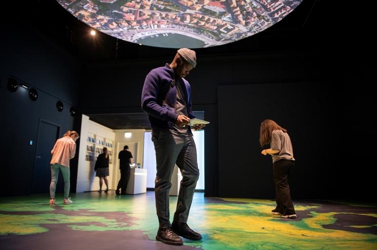 Un visiteur marche sur la carte de l'Euope avec une tablette