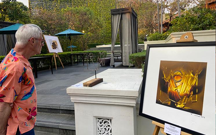 Un visiteur regarde une peinture de l'artiste francais Francois Renno a Chiang Mai