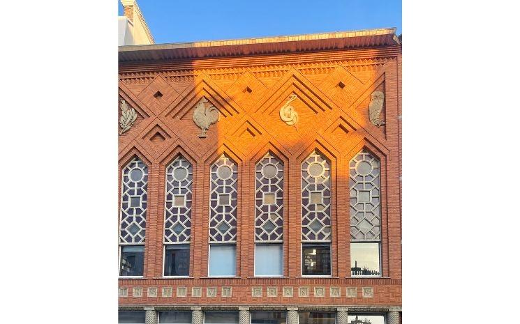 Façade Art Déco de l’Institut français et ses 4 symboles : l’olivier pour la paix, le coq pour le courage, le serpent pour le savoir et la chouette pour la sagesse