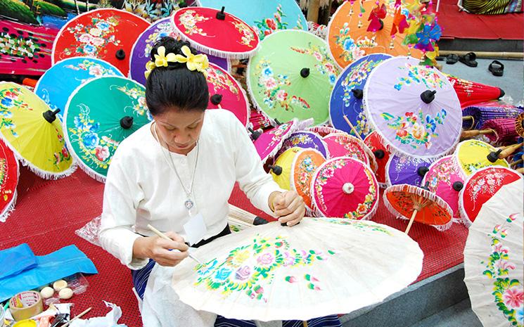 Une Thailandaise peint sur une ombrelle en papier dans le village de Bo Sang pres de Chiang Mai