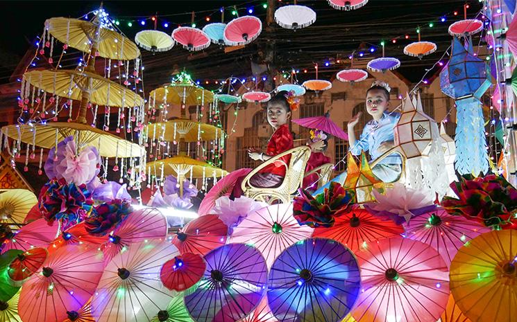 Des enfants thailandaises posent devant une installation lumineuse faite d'ombrelles a Bo Sang pres de Chiang Mai en Thailande