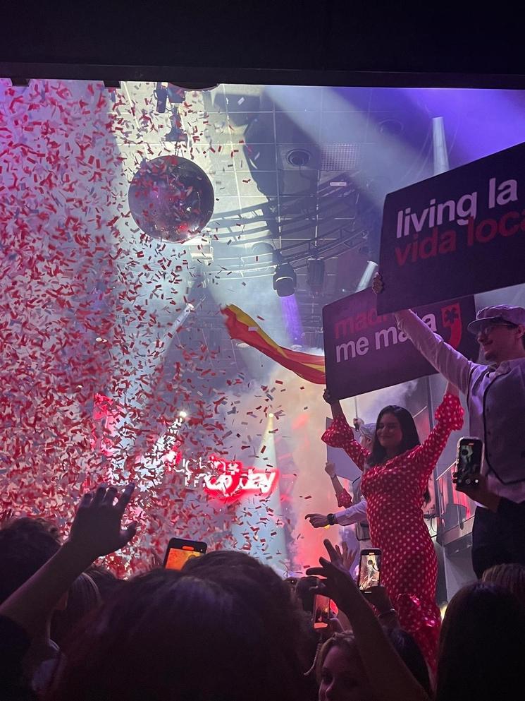 Photo prise lors de la soirée du fucking monda à Madrid avec une femme portant une pancarte "Me mata Madrid" et des confettis qui tombent par milliers