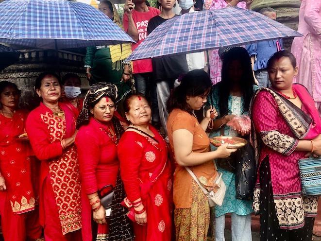 Femmes népalaises attendant les offrandes pendant Gai Jatra