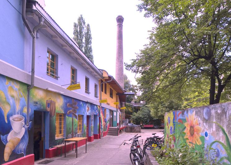Photo des murs recouverts de fresques colorées de la Regenbogenfabrik, un lieu alternatif à Berlin