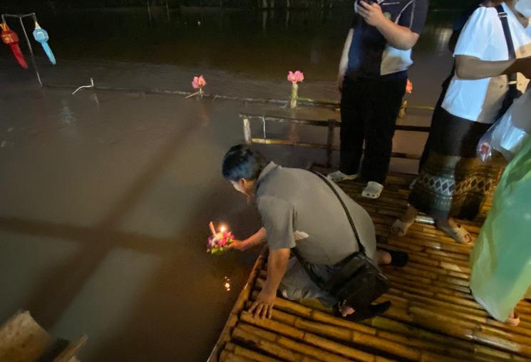 Homme lance Krathong de nuit