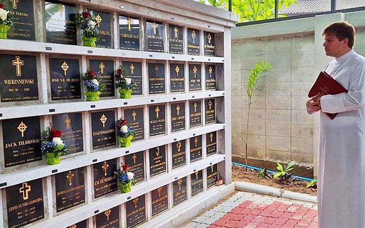 Le pere Brice des Missions Etrangeres de Paris benit les tombes de soldats et marins francais tombes pour la France au Siam dans le cimetiere Santhikam a Bangkok