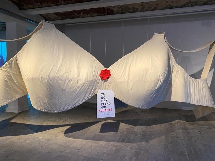 Un soutien gorge géant et blanc est exposé, avec une pancarte entre les deux bonnets